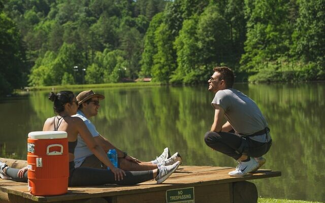A trio of campers enjoy some rest and relaxation by the scenic lake // Photo Credit: Jason Belsky