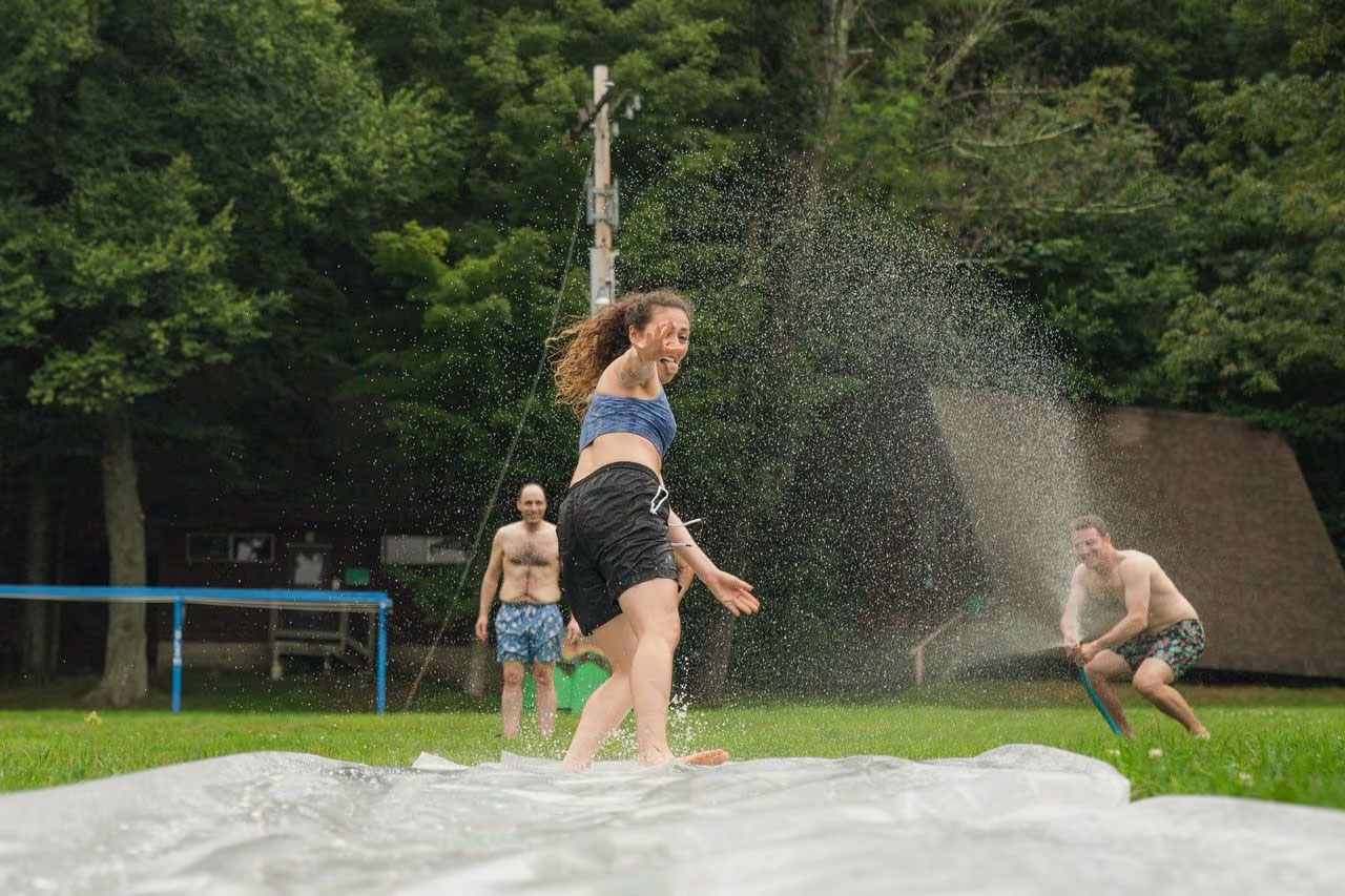 Staff member Ari Warsawski sprayed a slip-n-slide course for camper Reanna Karp from Raleigh, NC.JAY BELSKY